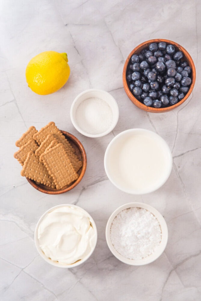 Blueberries, lemon, and dairy ingredients for dessert preparation.