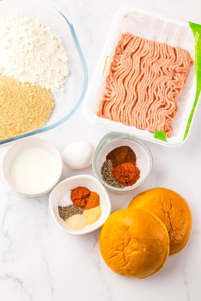 Fresh ground beef, buns, and spices for making juicy beef sliders.