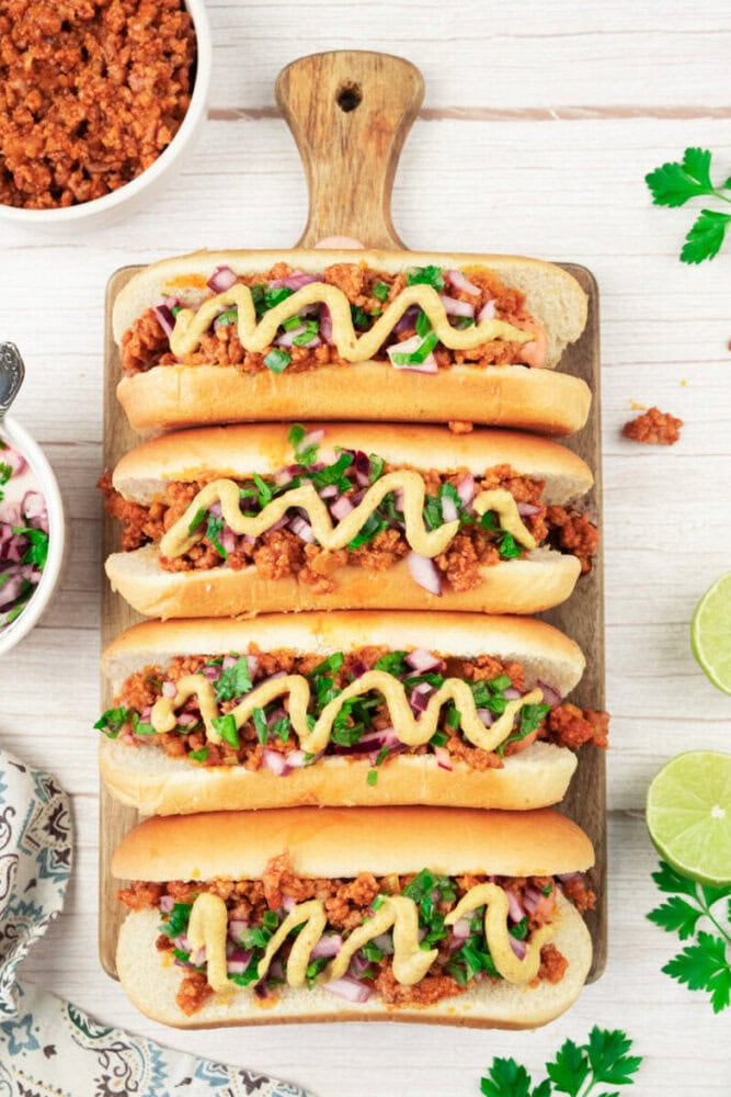 Sloppy Joes sandwiches with seasoned ground beef, topped with mustard and fresh herbs on a wooden se.