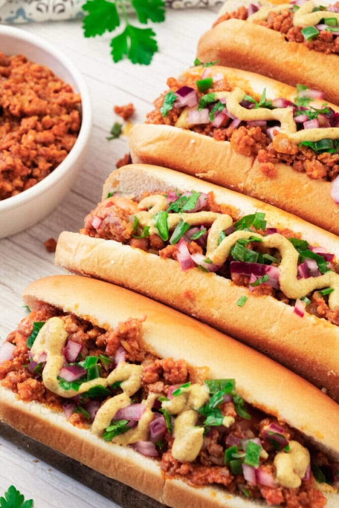 Beef tacos filled with seasoned ground meat, topped with chopped onions, cilantro, and drizzled with.