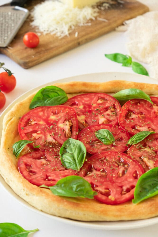 Delicious homemade pizza topped with ripe tomatoes and fresh basil leaves.