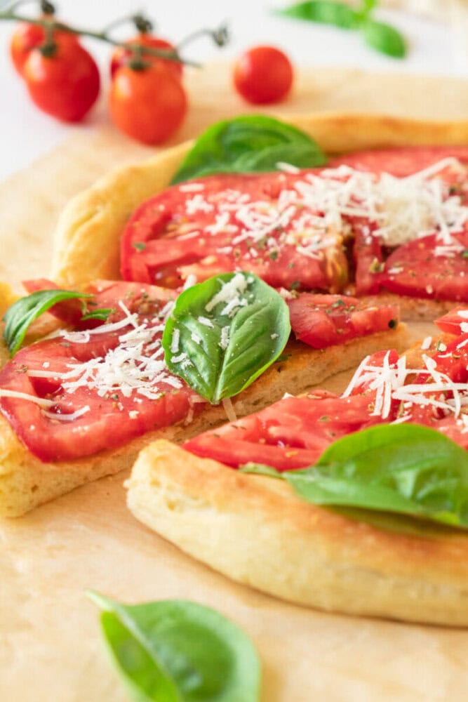 Delicious flatbread pizza topped with fresh tomatoes, basil, and grated cheese.