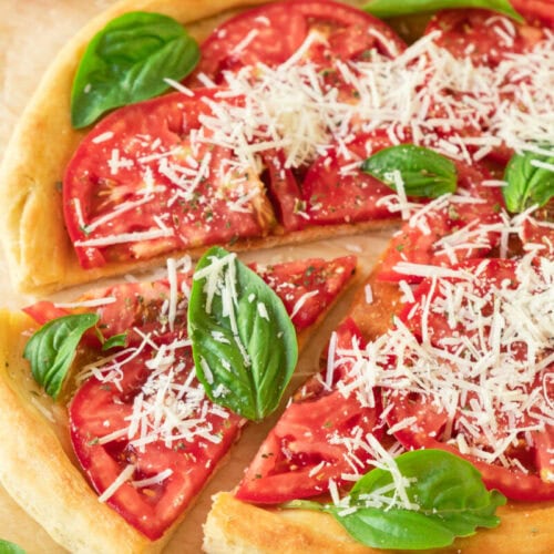 Fresh tomato and basil pizza with grated cheese on a crispy crust.