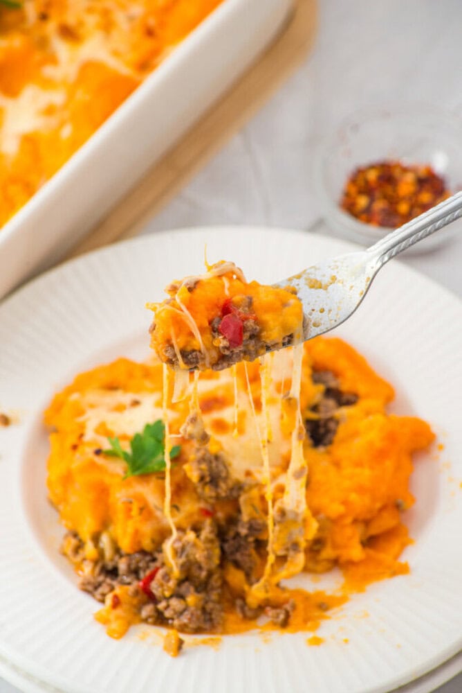 Delicious cheesy beef and mashed potatoes casserole with melted cheese and herbs.