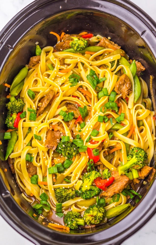 Delicious stir-fry noodle bowl with broccoli, peppers, and beef slices in a slow cooker.