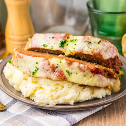Delicious chicken parmesan topped with melted cheese, served with creamy mashed potatoes and fresh basil.