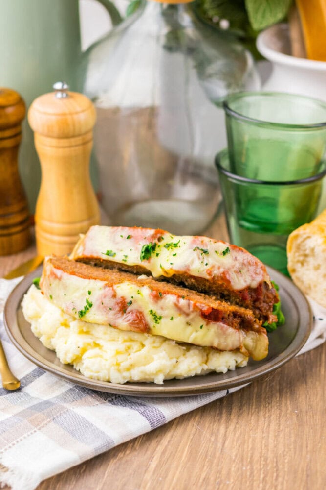 Delicious grilled chicken sandwich topped with melted cheese and herbs, served with creamy mashed po.