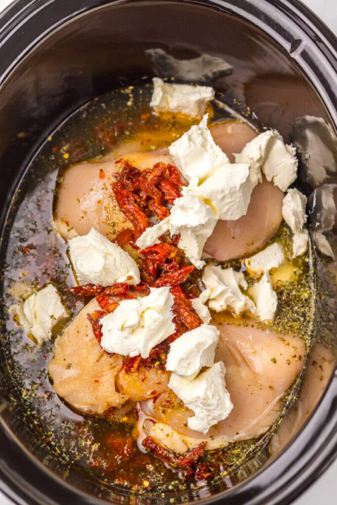Slow cooker chicken with sun-dried tomatoes, mozzarella, and herbs for a flavorful meal.