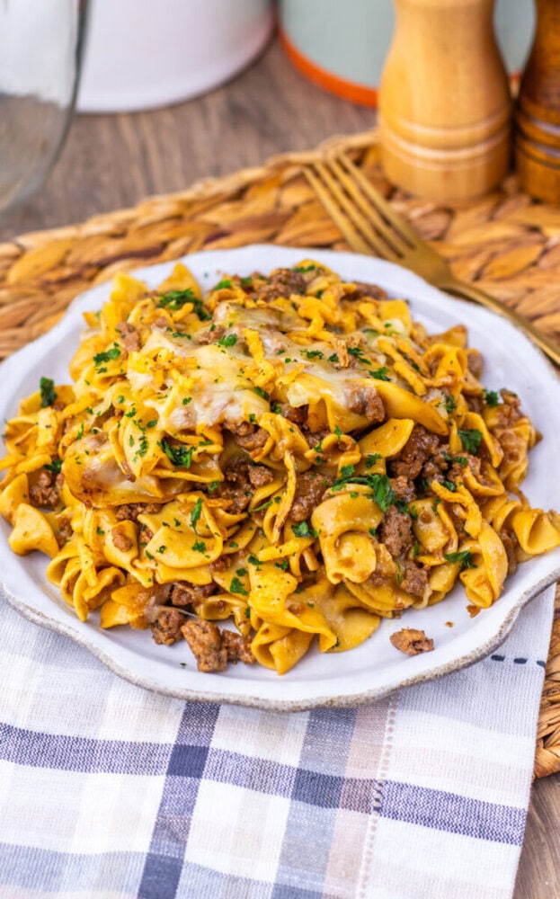 Delicious beef and egg noodle stir-fry with vegetables on a white plate.