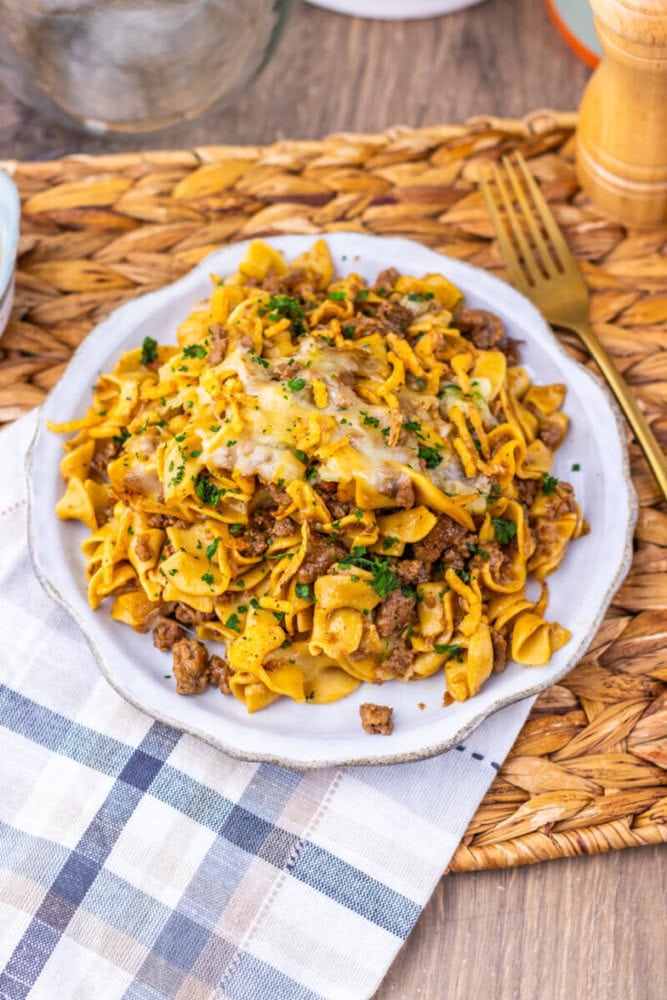 Delicious creamy beef and egg noodles served on a white plate with herbs.