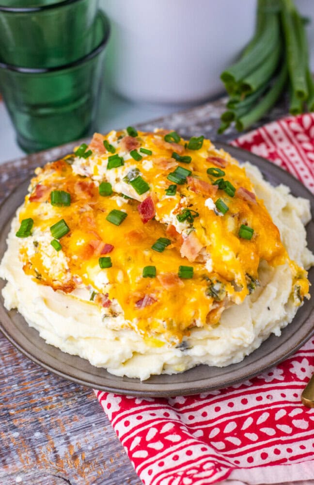Delicious baked salmon topped with melted cheese and fresh green onions, served over creamy mashed p.