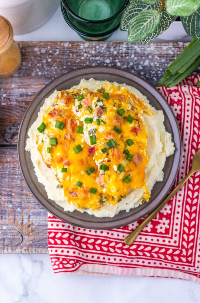 Delicious mashed potatoes topped with melted cheddar cheese and chopped green onions.
