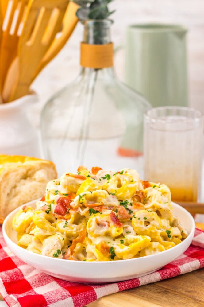 Delicious creamy chicken pasta with vegetables in a white bowl.