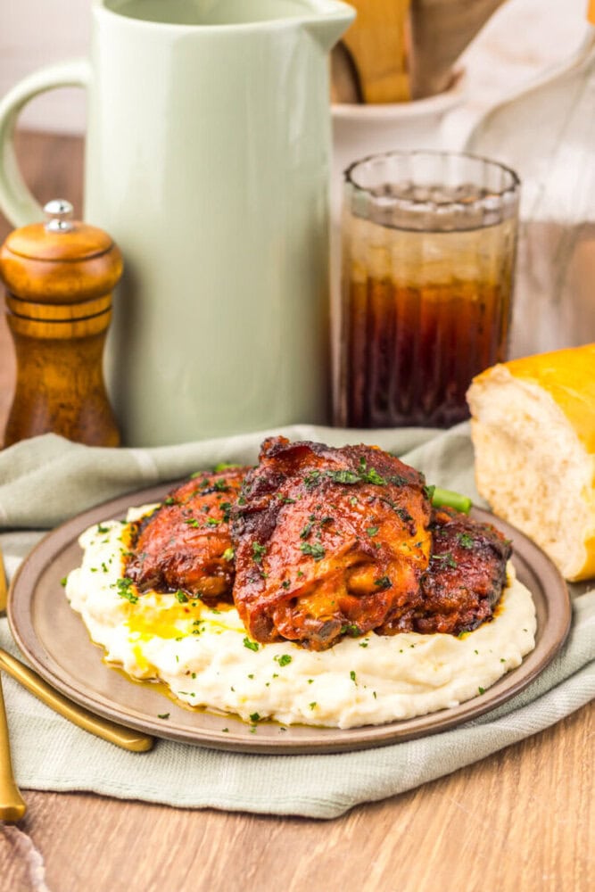 Delicious baked chicken thighs served over creamy mashed potatoes with herbs. Perfect comfort food f.