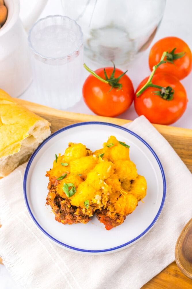 Delicious shepherd's pie with mashed potatoes, ground meat, and vegetables on a white plate.