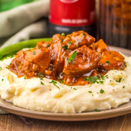 Delicious beef stew served over creamy mashed potatoes with herbs.