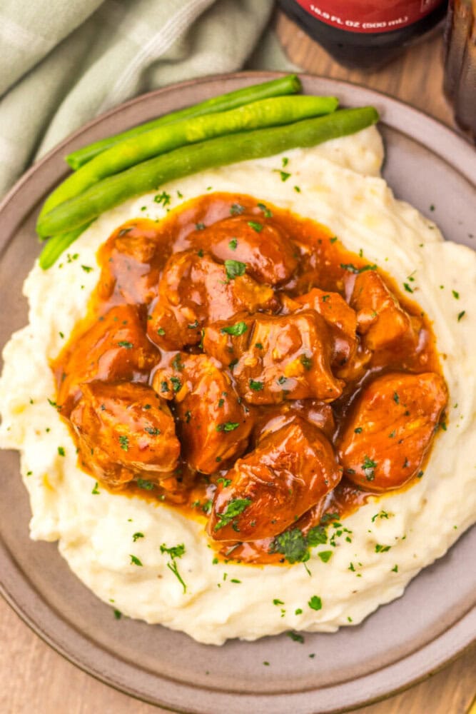 Delicious beef stew served over creamy mashed potatoes with fresh green beans on the side. Perfect c.