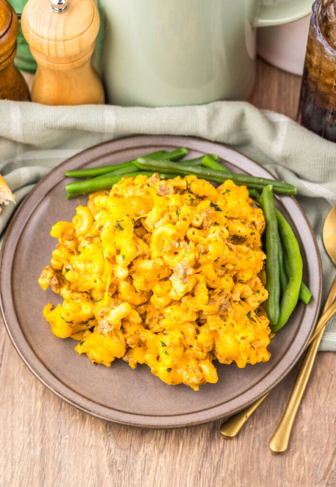 Delicious cheesy mashed potato casserole with green beans on a rustic plate.