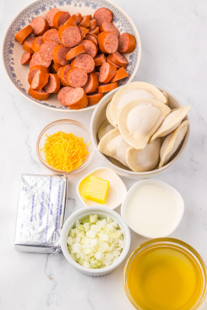 Delicious grilled sausage slices with steamed dumplings, cheese, onions, and creamy sauce, perfect f.