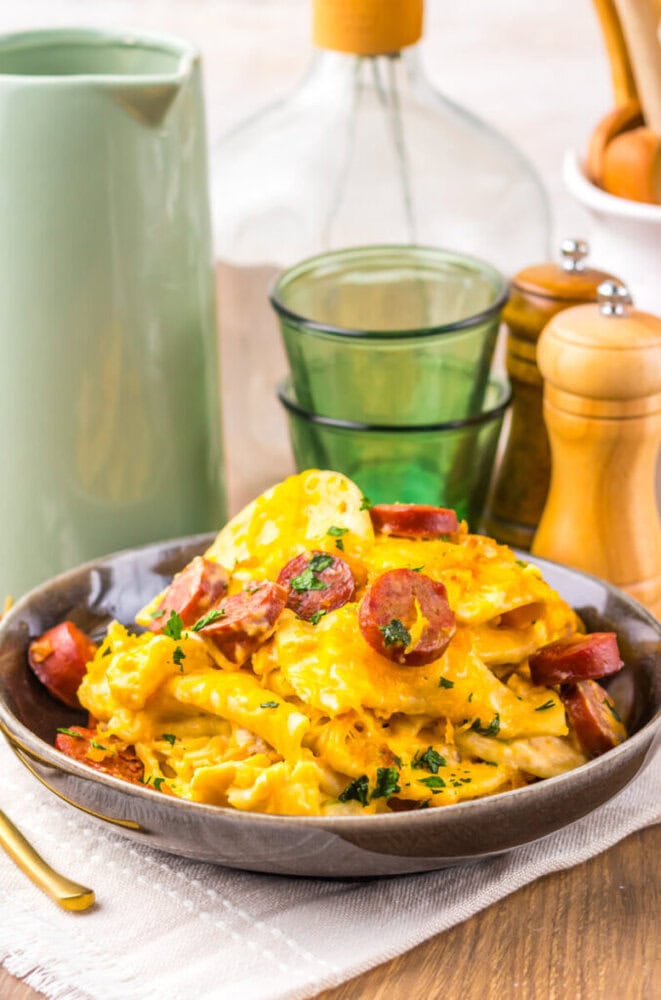 Delicious creamy sausage and egg pasta served in a bowl with herbs.