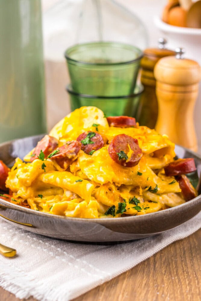 Delicious creamy sausage and egg pasta served in a bowl with herbs.