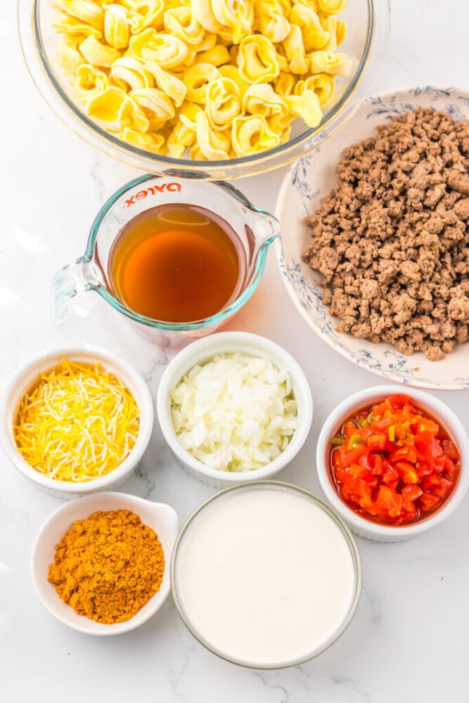 Cooked pasta with ground beef, cheese, and vegetables in a baking dish.