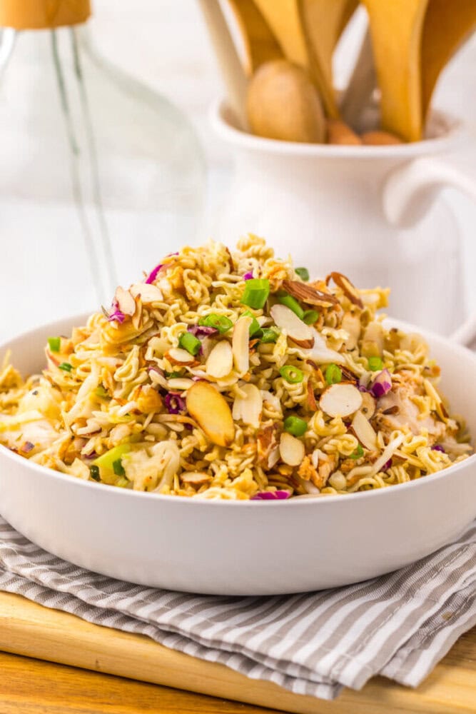 Delicious chicken ramen noodle salad with vegetables and almonds in a white bowl.