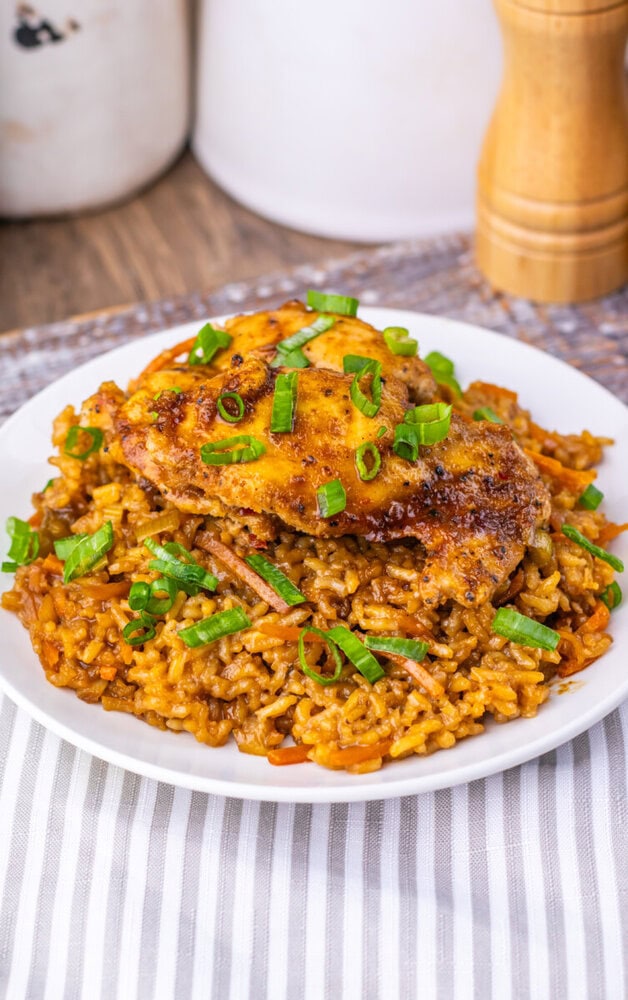 Delicious baked chicken served over flavorful seasoned rice garnished with chopped green onions. Per.