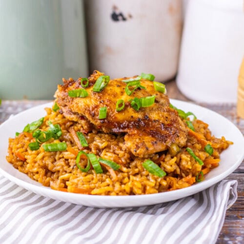 Crispy fried chicken served over flavorful spiced rice garnished with green onions.