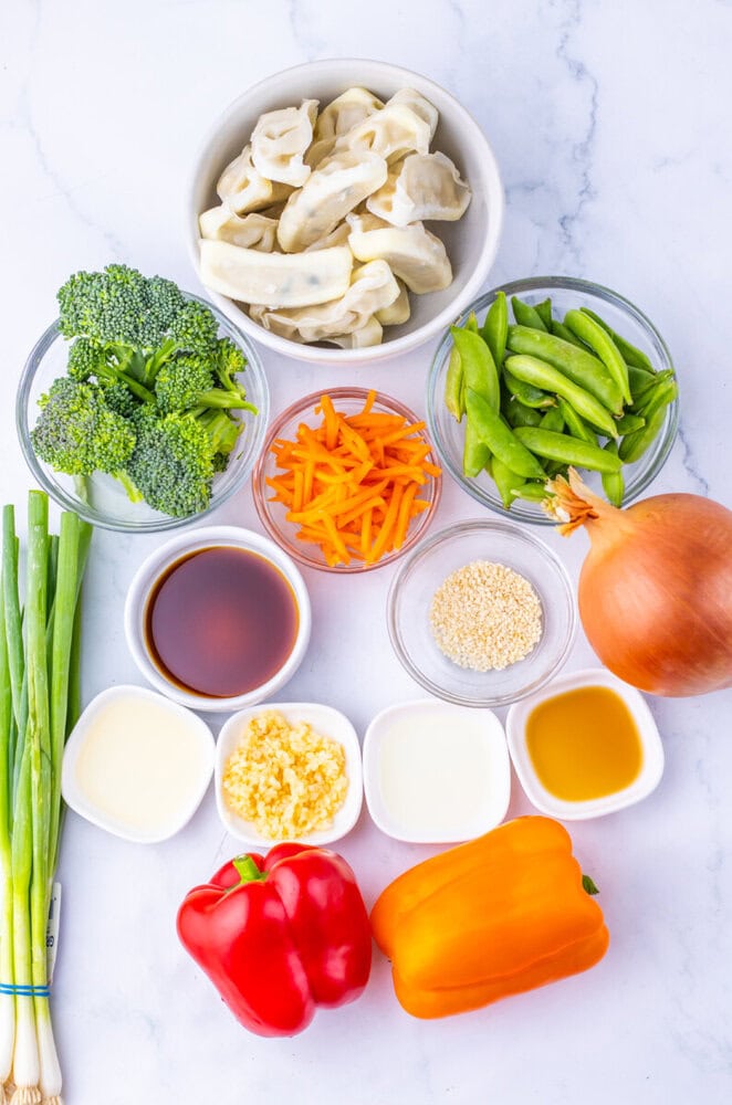 Colorful vegetable ingredients including broccoli, bell peppers, snap peas, carrots, onion, and garl.