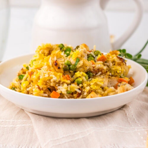 Tasty vegetable fried rice with colorful vegetables and rice in a white bowl.