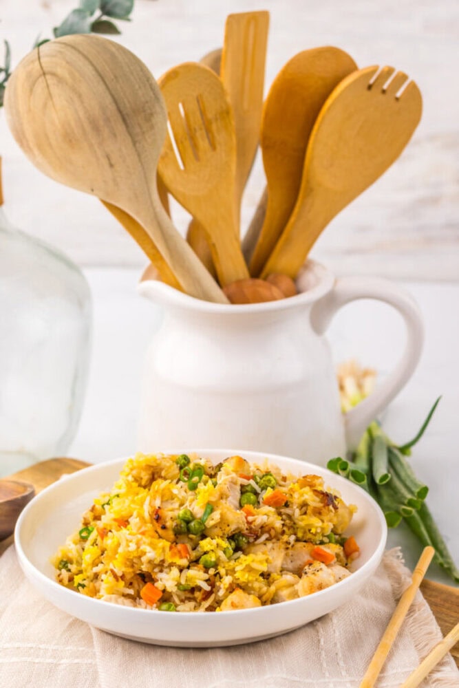 Tasty shrimp fried rice with vegetables served in a white bowl.