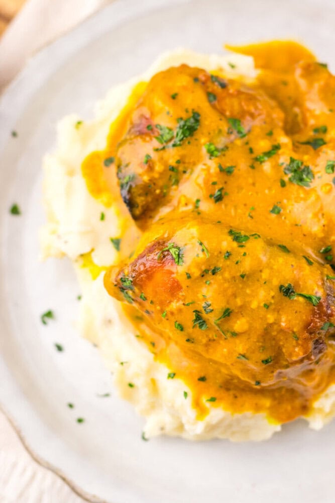 Juicy chicken thighs in flavorful gravy served over creamy mashed potatoes.