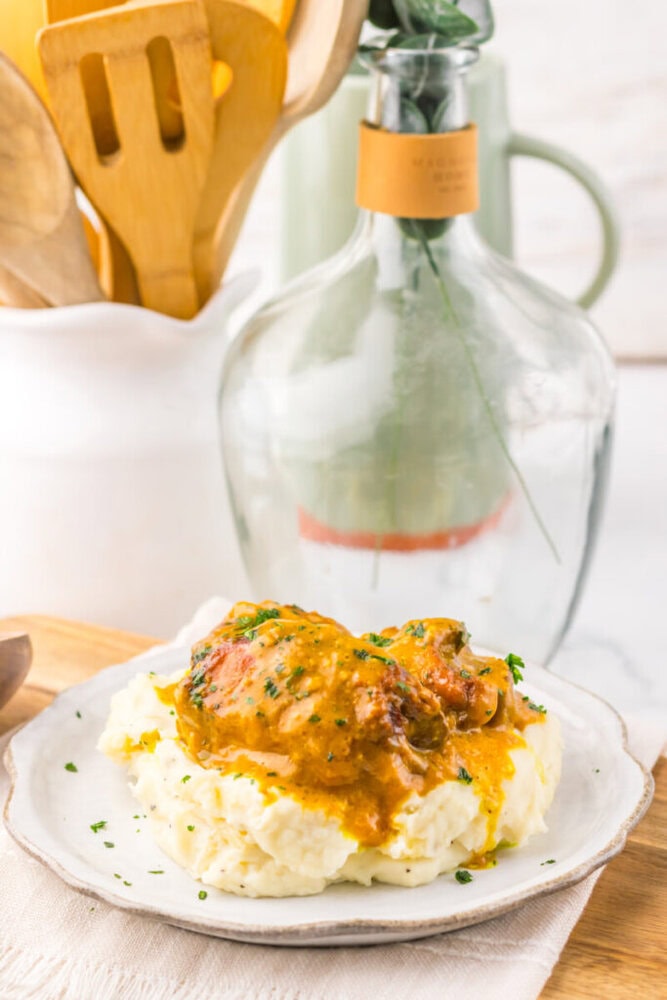 Delicious chicken pot pie served over creamy mashed potatoes with herbs.