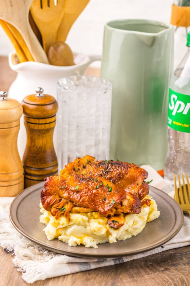 Delicious baked chicken served over creamy mashed potatoes with gravy, perfect for a hearty, satisfy.