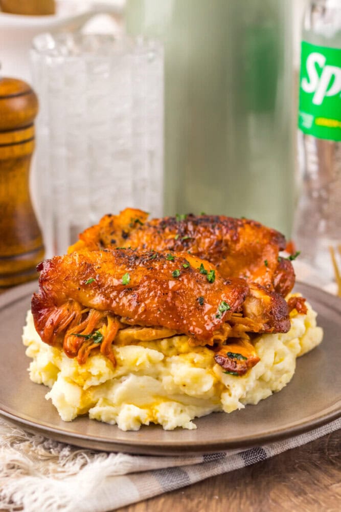 Delicious baked chicken thighs served over creamy mashed potatoes, garnished with herbs for a hearty.