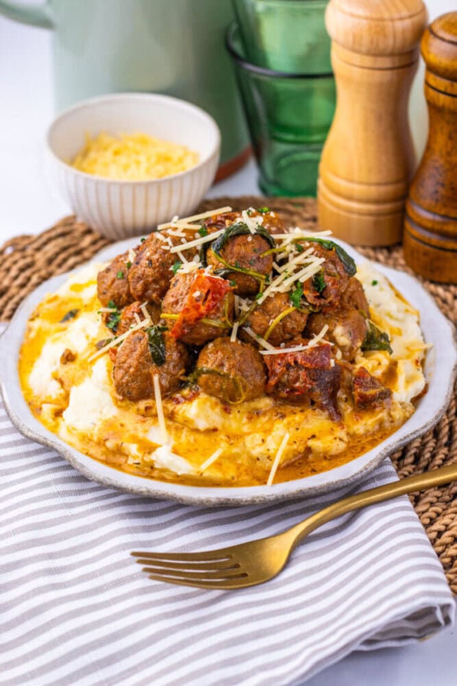 Delicious spaghetti with meatballs, tomato sauce, and cheese on a white plate.