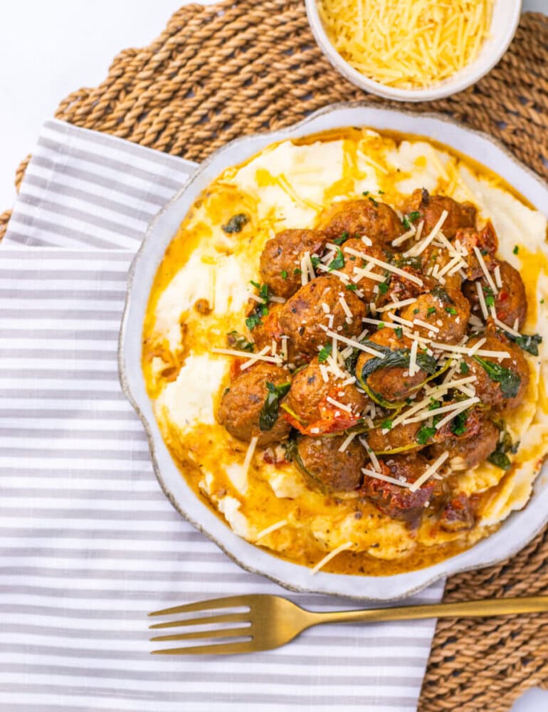 Delicious cheesy meatball parmesan bake with melted cheese and fresh herbs.
