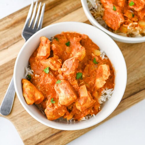 Delicious creamy chicken curry served over fluffy white rice in a white bowl.