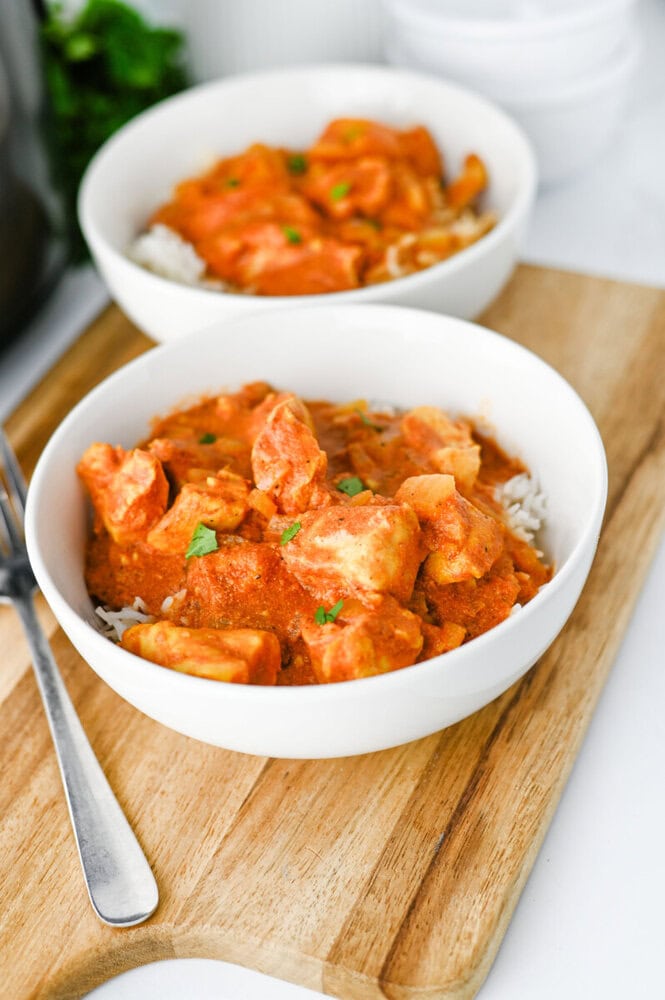 Delicious creamy chicken curry served over rice in white bowls.