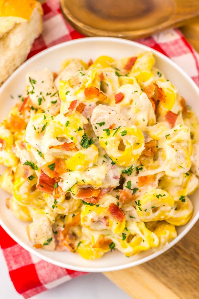 Sheet Pan Chicken Bacon Ranch Tortellini with parsley garnish and bacon served on white plate