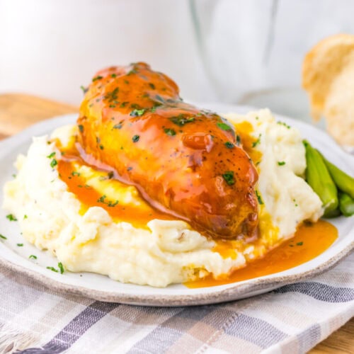 Delicious chicken pot pie topped with gravy, served over creamy mashed potatoes with green beans on.