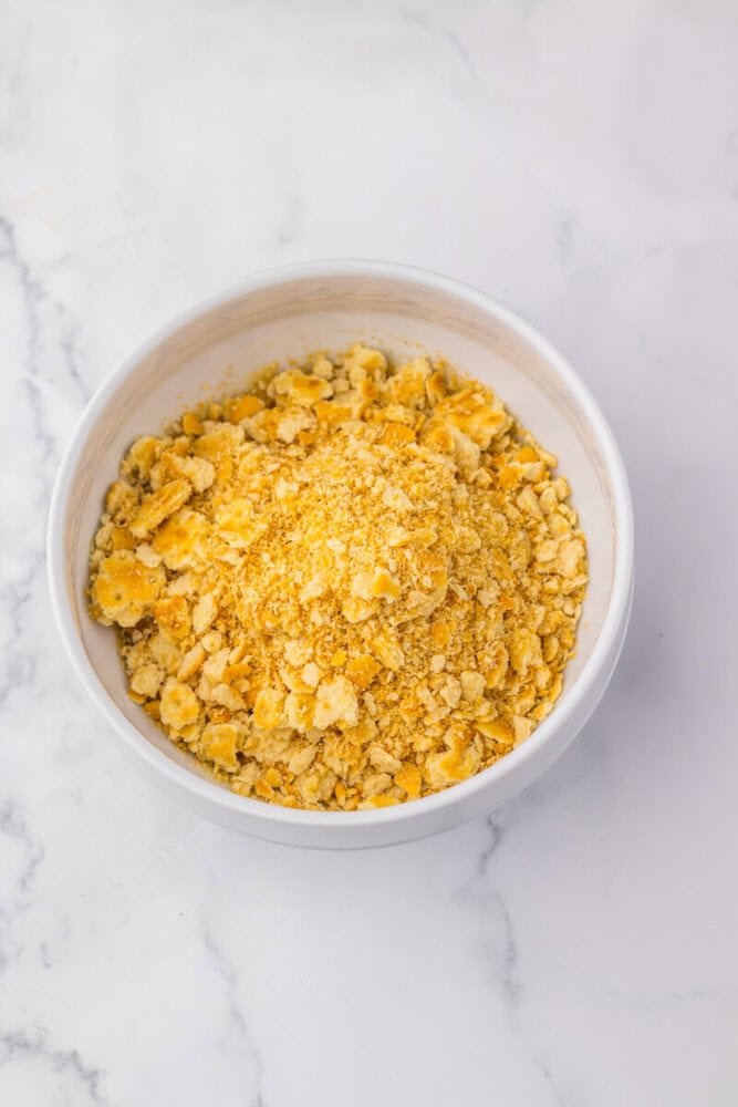 Crumb topping in a white bowl, perfect for pies and desserts, on a marble surface.