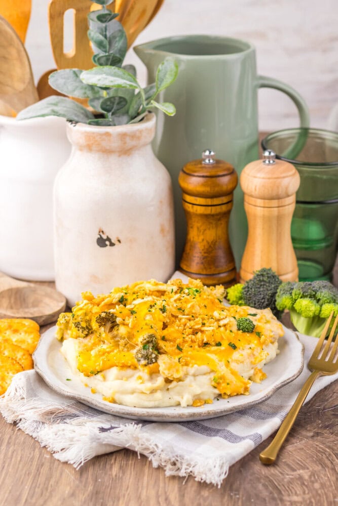Delicious broccoli chicken casserole with cheese and herbs on a rustic table.