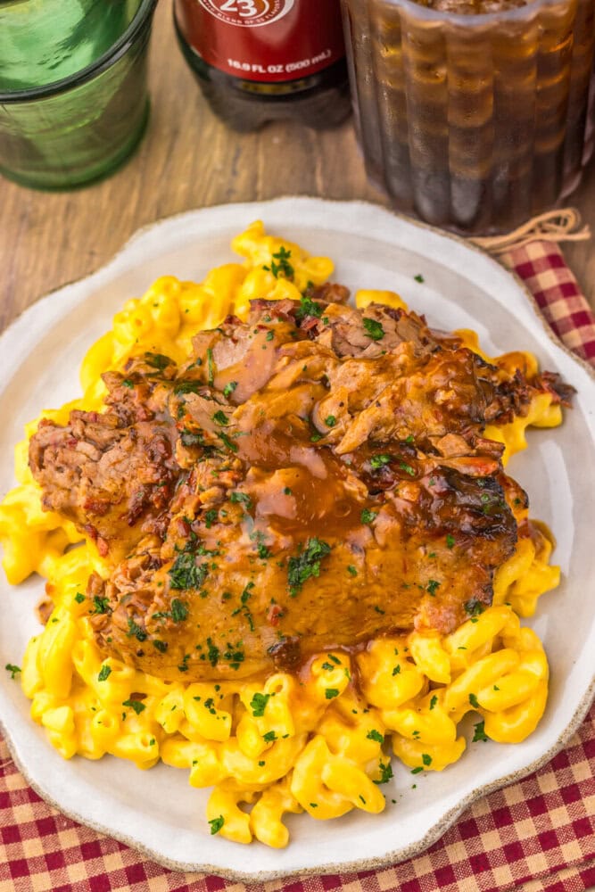 Delicious chicken fried steak served over creamy macaroni and cheese with gravy and herbs. Perfect c.