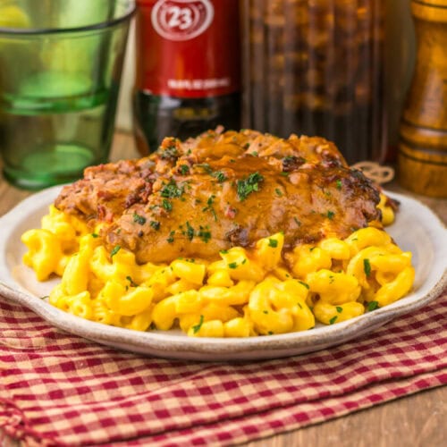 Delicious baked mac and cheese topped with tender chicken and herbs, perfect for comfort food lovers.