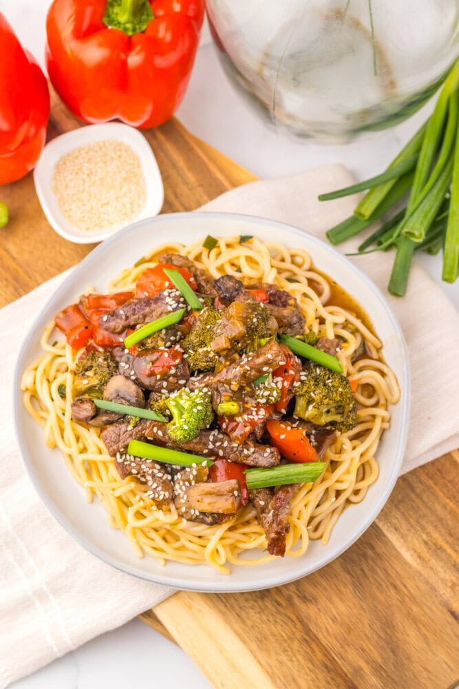 Delicious spaghetti with beef, broccoli, and bell peppers on a white plate.