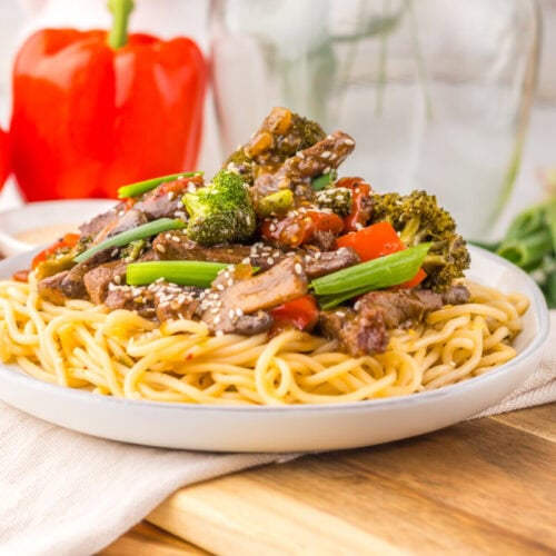 Delicious vegetable beef stir-fry served over noodles with colorful peppers and broccoli.