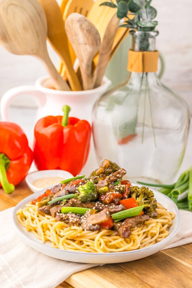 Delicious vegetable stir-fry served over spaghetti pasta with colorful bell peppers and broccoli.