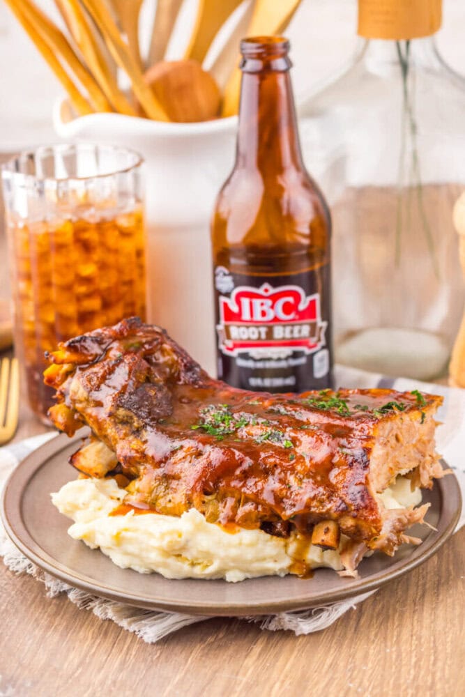 Juicy BBQ ribs served with creamy mashed potatoes on a rustic plate.